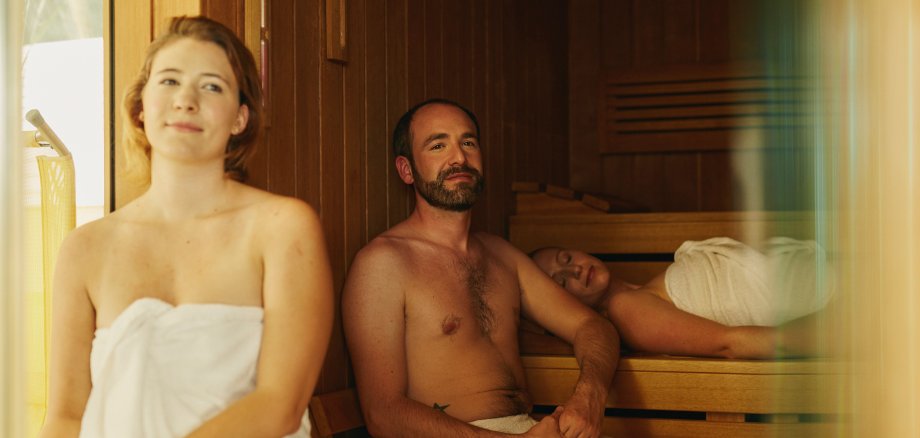 Drei entspannende Menschen in der Sauna 