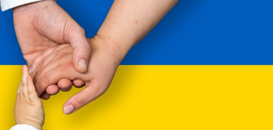 Eine Ukraine Flagge mit Händen davor.