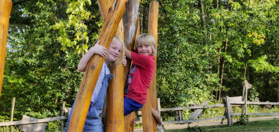 Zu sehen sind zwei Kinder auf dem Waldspielplatz des Walderlebniszentrums.