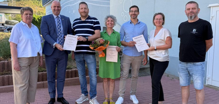 25-jährige Dienstjubiläen beim Zweckverband Wasserversorgung Trollmühle in Windesheim 7 nebeneinanderstehende Menschen, einige halten Urkunden in der Hand